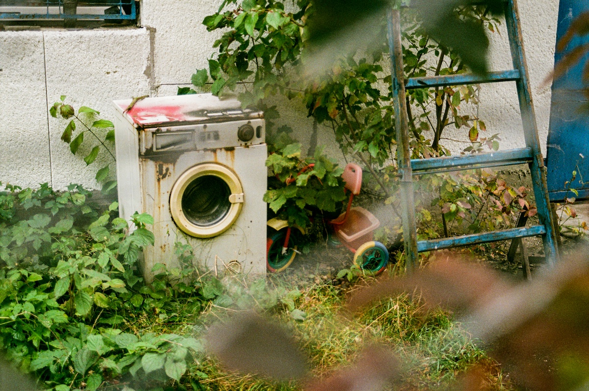 Old refrigerator and washer staged for haul-away pickup